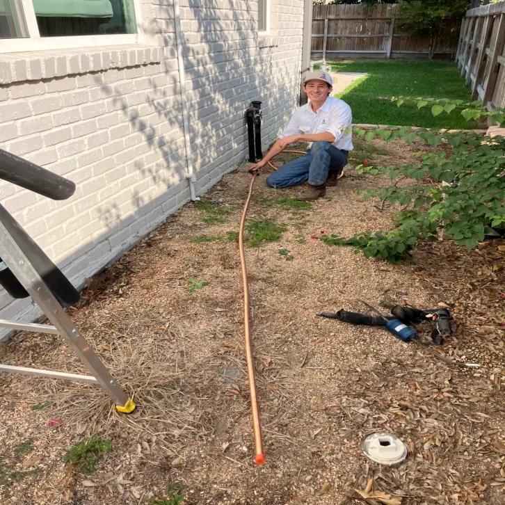 Technician running a new refrigerant line set for a system replacement